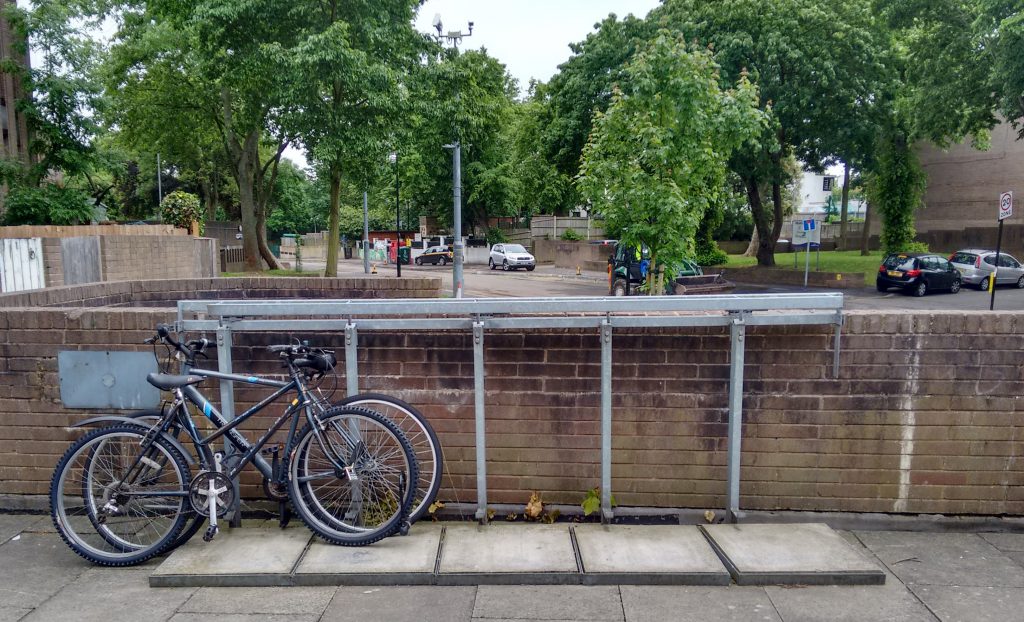 Bikes locked to a wheelie-bin rack